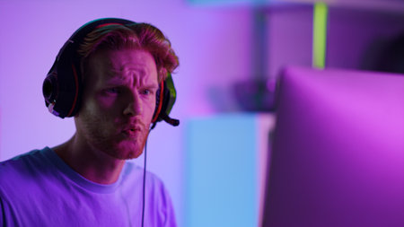 Gaming streamer talking online at cyberspace closeup. Frustrated man play games resting with friends...
