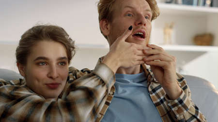 Wife watching movie husband on weekend closeup. Joyful family resting making fun at home. Beautiful...