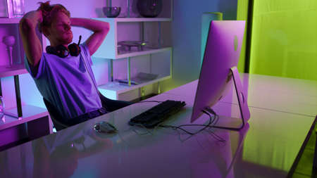Disappointed gamer losing tournament round in cozy home neon cyberspace studio. Upset man esport...