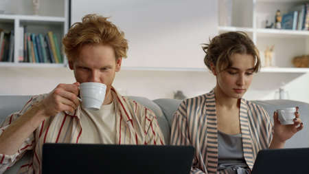 Family couple surfing web on weekend morning closeup. Focused managers working together in living...