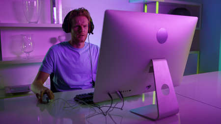 Neon player enjoy gaming tournament. Focused streamer blogger recording game. Excited student...