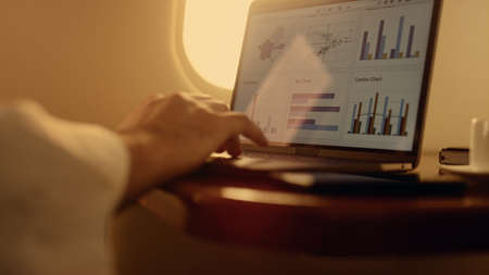 Hands working digital computer closeup. Manager checking company graphs on plane. Unrecognized...