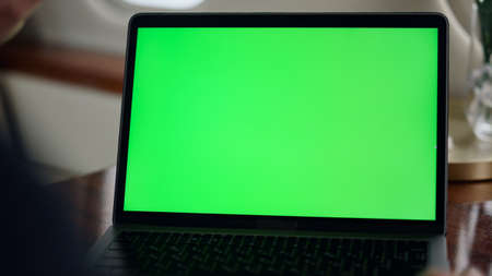 Closeup mockup laptop screen in airplane. Businessman watch chroma key computer checking company presentation data infographics on corporate trip. Unrecognized man manager working in private jet.の写真素材