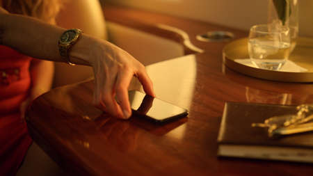 Businesswoman typing message smartphone closeup. Passenger flying private jet. Smiling elegant woman...
