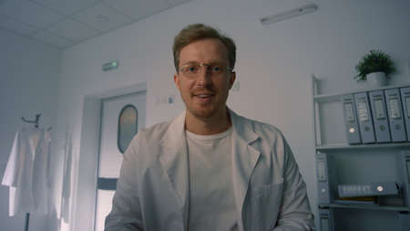 Friendly physician finishing online consulting in modern hospital office close up pov video....