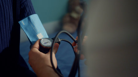 Doctor hands preparing tonometer to measure pressure child patient close up. Unknown man pediatrician checking equipment testing girl health in modern clinic. Healthcare in covid pandemic concept.の写真素材
