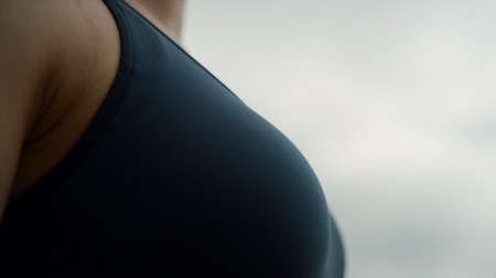 Peaceful young woman meditating standing on nature gloomy summer day close up. Sporty slim girl close eyes practicing yoga breathing exercise. View athletic healthy body wearing black sportswear.の写真素材