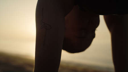 Silhouette fit girl making yoga asana on bright sunset light. Slim sportswoman standing marjariasana...