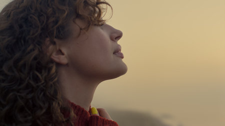 Portrait of peaceful woman enjoying sunrise on beach. Closeup romantic girl standing on ocean shore....