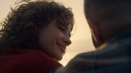 Portrait of affectionate couple dating on beach at sunset. Smiling girl looking on guy with love....