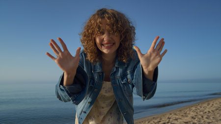 Cute attractive woman looking camera standing on beautiful beach close up. Portrait of smiling young...