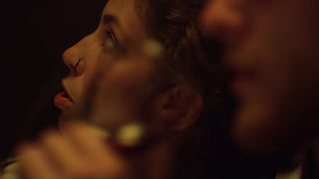 Closeup couple drink alcohol glass at evening. Lovers face enjoy wine on date. Two young people talk...