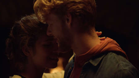 Affectionate lovers dance close on romantic night. Closeup young people whisper ear on date. Happy couple cuddle on holiday together. Dancing girlfriend boyfriend spend winter vacation. Love concept.の写真素材