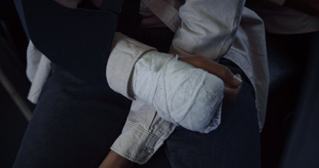 Smiling indian teen boy sitting school bus with broken hand close up. Joyful dark-haired student...