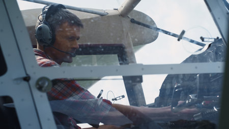Serious airman sitting in airplane cabin preparing for training flight close up. Focused...