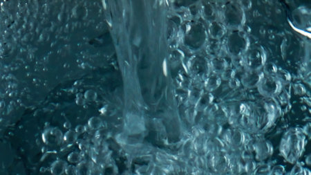 Bubbling beverage filling glass closeup. Top view diverse air bubbles rising exploding surface....