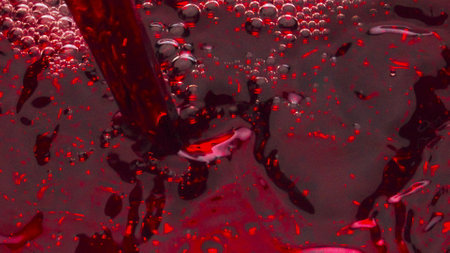 Closeup red liquid filling wineglass super slow motion. Alcoholic tasty wine splashing bubbling inside goblet. Refreshing rose beverage pouring glass top view. Luxury elegance tipple conceptの写真素材