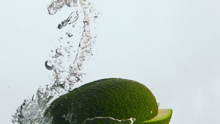Ripe fresh avocado pieces splashing water with bubbles in super slow motion close up. Green vitamin vegetable raising up in transparent liquid. Organic healthy food for tasty vegetarian nutrition.の写真素材