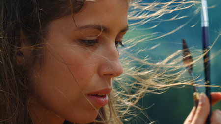 Portrait of inspired painter woman creating art in windy day. Closeup beautiful artist holding paint...