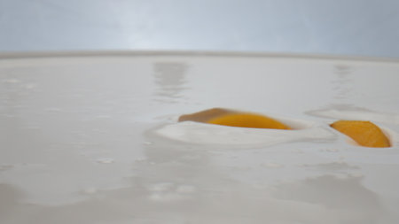Pieces sweet tasty apricot falling into fresh milk dessert in super slow motion close up. Juicy...