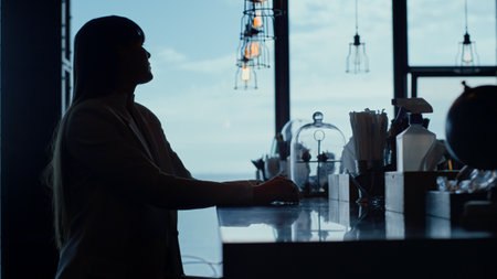 Lonely woman silhouette at sea view bar closeup. Unrecognized depressed businesswoman drinks alone...