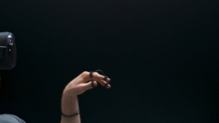 Future device student hands playing metaverse zoom out. Silver hair sensor gloves guy having VR experience sitting armchair. Focused man touching videogame space slow motion. Nano technologies conceptの写真素材