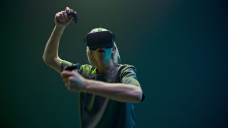 Youngster man practicing exercising using VR headset. Concentrated person defending from enemies with sword training at simulator competition game slow motion. Futuristic network experience conceptの写真素材