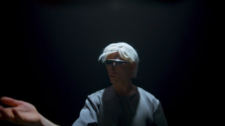 Guy touch virtual objects in futuristic glasses closeup. Cyber player experience augmented reality in dark space. Focused blonde teenager enjoying metaverse simulation in light. Man wearing vr gogglesの写真素材