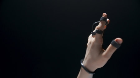 Closeup haptic sensor hands touching metaverse. Unrecognizable person trying virtual reality videogame. Anonymous user exploring social media platform black background. Technology era next generationの写真素材