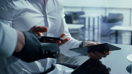 Unknown elegant businessman paying lunch bill using fast contactless payment technologies. Closeup man hands putting smartphone nfc app on portable pos terminal. Cashless money transfers concept.の写真素材