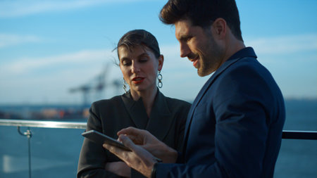 Happy colleagues looking tablet in sunlight closeup. Handsome executive typing pad screen checking...
