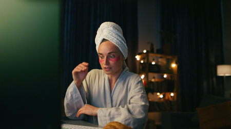 Smart lady talking computer at night home closeup. Skilful freelancer gesturing explaining pc monitor device at evening. Domestic woman talking virtual call at dark room. Remote work conceptの写真素材