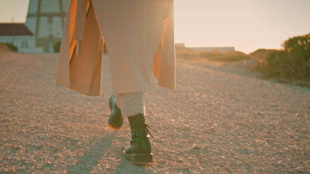 Girl legs walking road in sunlight closeup. Relaxed woman enjoy autumn evening at countryside....