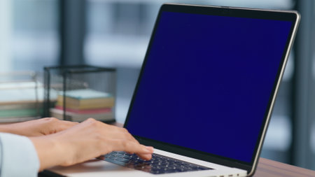 Anonymous ceo texting chromakey laptop closeup. Entrepreneur arms pressing buttons on blue screen device keyboard. Unknown director working macro view. Executive hands typing information chattingの写真素材