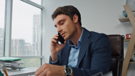 Smiling entrepreneur talking mobile phone closeup. Confident executive working discussing corporate strategy with partner remotely. Successful lawyer speak consulting client. Busy office lifestyle.の写真素材