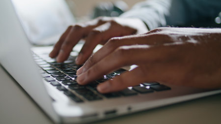 Guy hands typing keyboard laptop at apartment closeup. Brown skin man arms pressing computer buttons...