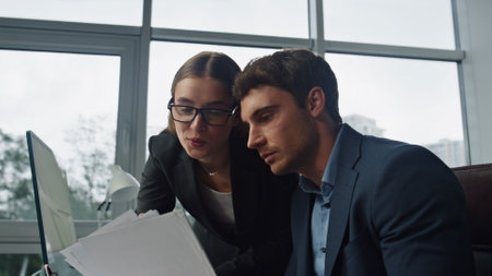 Office managers checking contract together closeup. Lawyer consulting client reading explaining documents. Focused supervisor helping corporate trainee. Financial analyst assist thoughtful executive.の写真素材