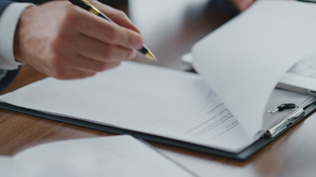 Man hands putting signature on official documents with pen close up. Unknown businessman signing...