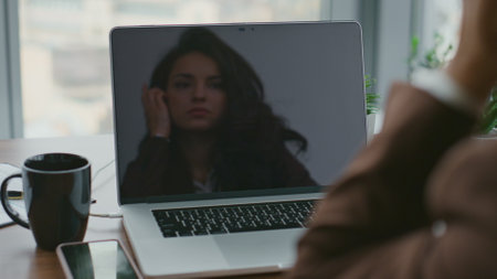 Serious business lady looking laptop screen sitting at work desk with coffee cup close up. Brunette businesswoman working at computer sitting in office. Thoughtful attractive woman making break.の写真素材