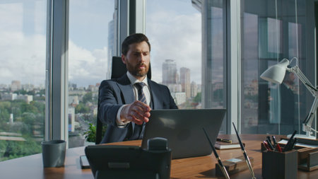 Thoughtful business man shutting laptop sitting at office desk feeling stressed. Bearded executive manager thinking about work problems at crisis. Serious financial specialist solving company issues.の写真素材