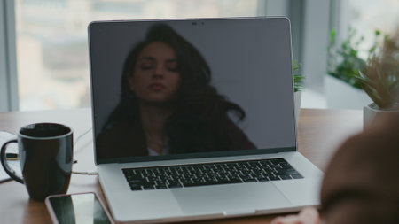 Smart woman manager speaking on web camera conducting video call in office closeup. Confident businesswoman reflecting in laptop screen talking at online conference sitting desk. Business lady workingの写真素材