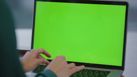 Woman hands typing on keyboard green screen laptop working office close up. Unknown businesswoman using chroma key computer writing message preparing report searching information. Mock-up monitor.の写真素材