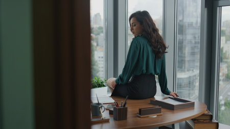 Professional woman lawyer making notes in notebook sitting office desk. Attractive confident girl ceo manager writing business ideas in notepad. Elegant smart lady economist working in company cabinetの写真素材