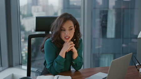 Attractive smart business lady talking on virtual meeting looking at laptop web camera. Confident woman executive manager having online negotiation using video chat. Elegant consultant speaking webcamの写真素材