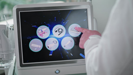 Cosmetologist hand adjusting operation modes at screen laser lifting device close up. Unknown doctor choosing beauty procedure touching equipment display. Modern technology in cosmetology clinic.の写真素材