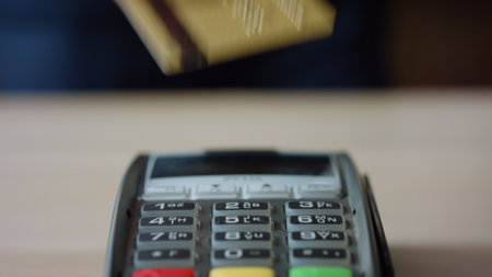 Closeup contactless plastic card transaction on bank wireless terminal. Unknown man making cashless payment using nfc technology. Male hand paying bill touching electronic pos reader with credit card.の写真素材