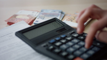 Man hands pressing numbers on calculator counting money expenses at office close up. Unknown businessman calculating income outcome checking bills pay taxes. Accounting planning budget savings conceptの写真素材