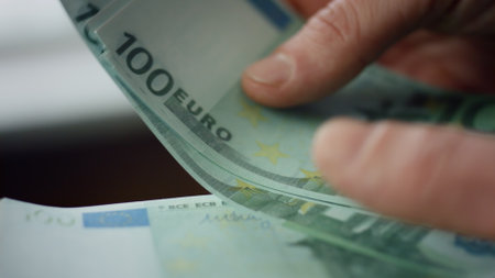 Cashier hands counting money euro cash close up. Unknown man keep lot of bills european currency indoors. Male fingers holding hundreds banknotes. Employee salary business profit bank loan concept.の写真素材