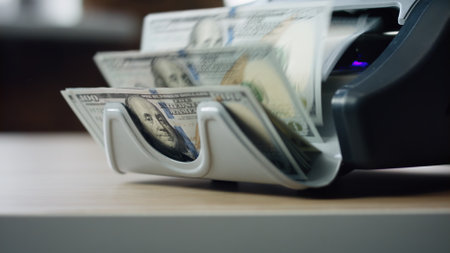 Modern automatic machine counting american dollar bills denomination of hundred close up. Electronic equipment for paper money calculation. Device for bank cash currency operations. Finance conceptの写真素材