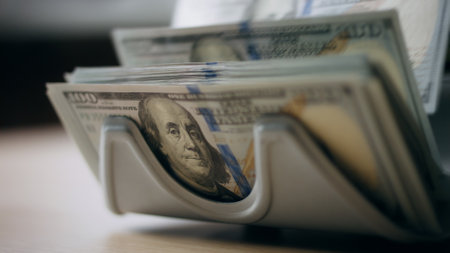 Automatic counter accumulating money cash denomination of hundred dollars close up. Bank equipment for calculation paper american currency banknotes. Modern machine for bills counting. Finance conceptの写真素材